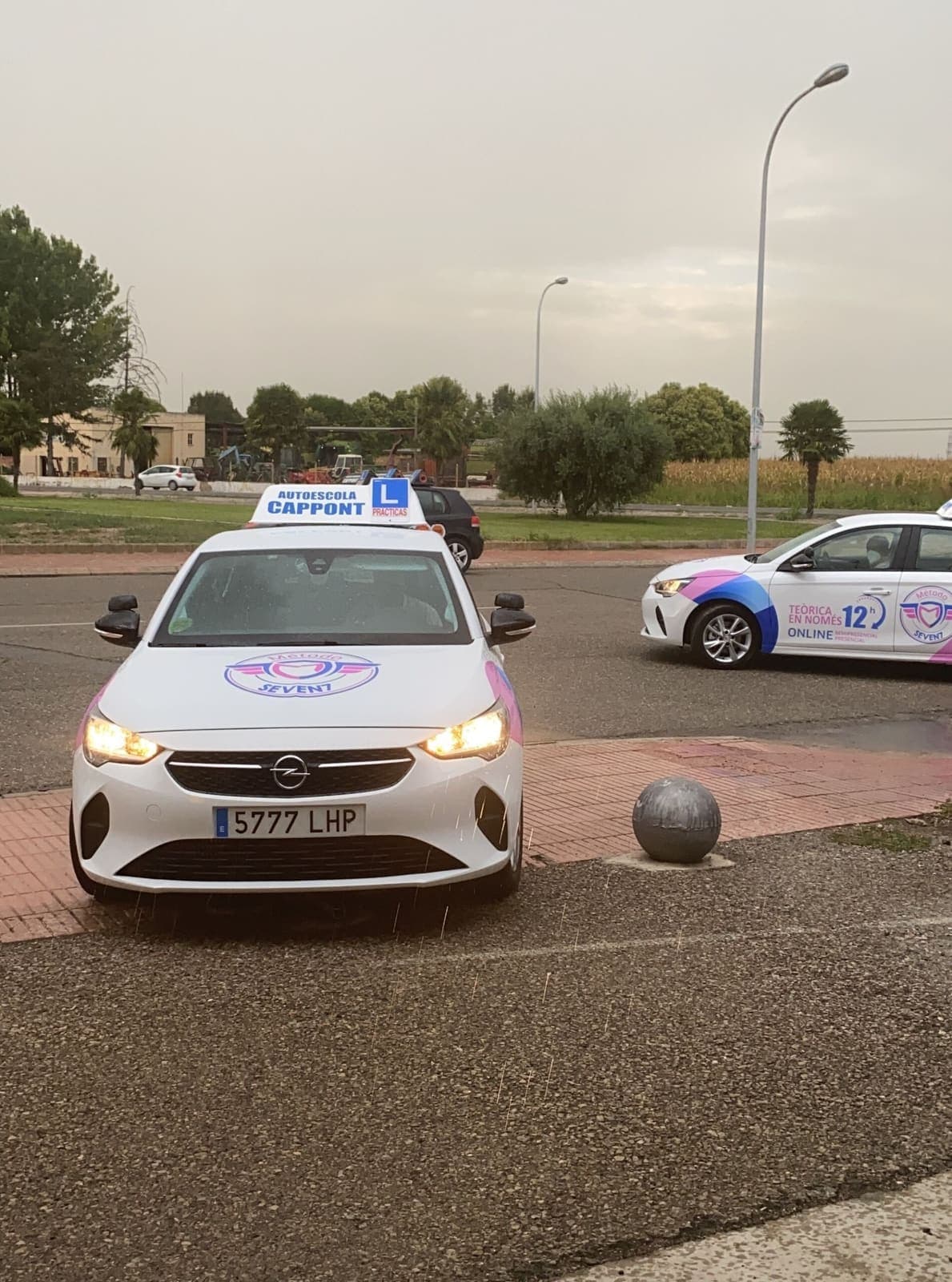 Dos cotxes de pràctiques de l’autoescola en una zona d’examen.